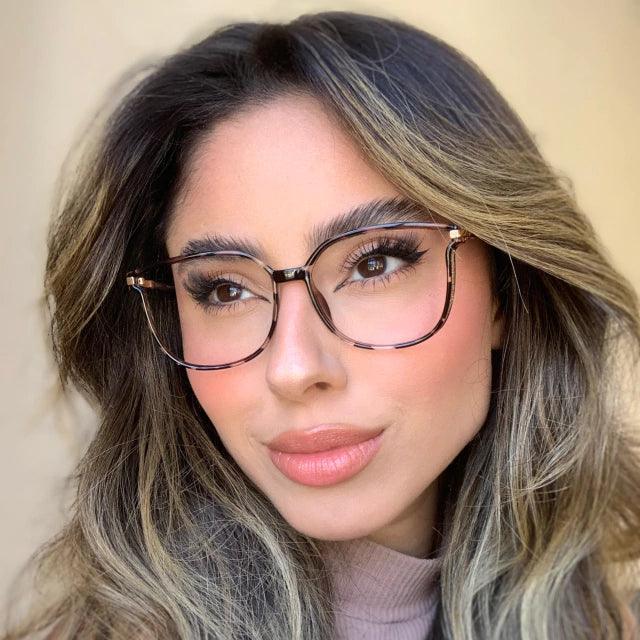 Óculos multifocal feminino com lentes transparentes, armação leve nas cores preta e marrom translúcida. Modelo com proteção contra luz azul e design sofisticado para uso diário.