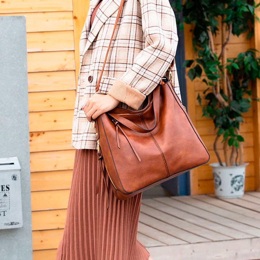 Bolsa de couro feminina com alça dupla, zíper seguro e design elegante. Modelo versátil, disponível em preto e caramelo, ideal para o dia a dia com estilo e sofisticação.