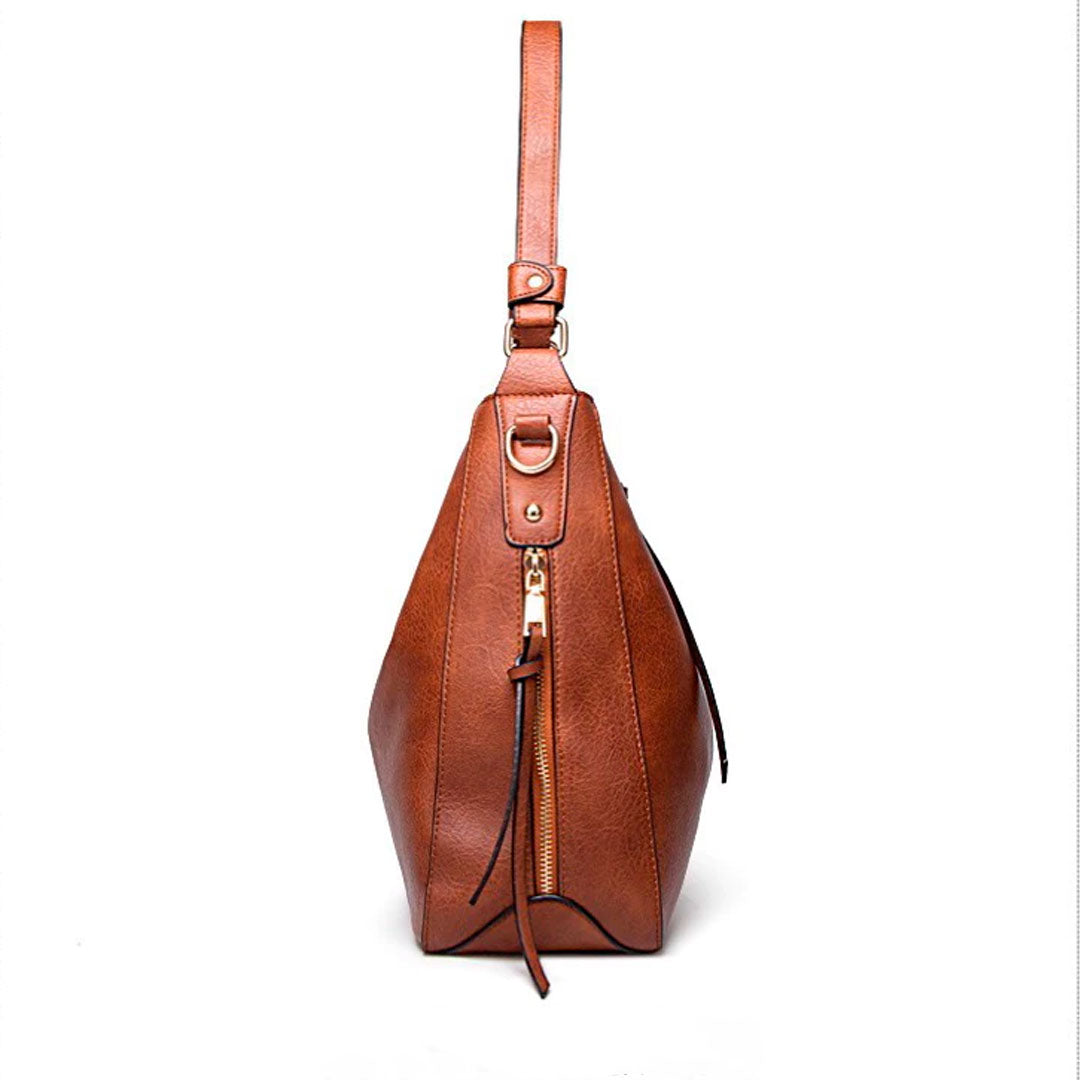 Bolsa de couro feminina com alça dupla, zíper seguro e design elegante. Modelo versátil, disponível em preto e caramelo, ideal para o dia a dia com estilo e sofisticação.