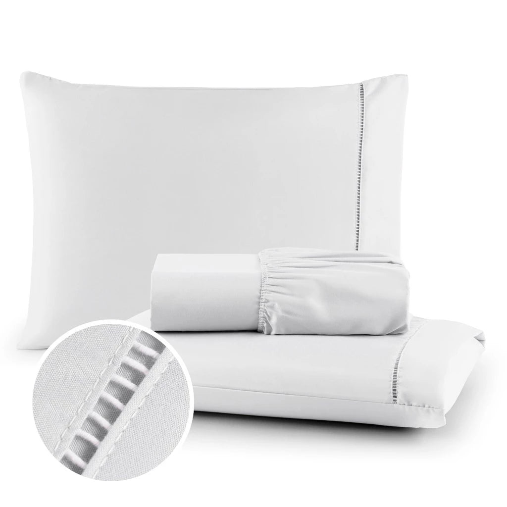 Conjunto de lençol de micropercal 400 fios disponível nas cores branca, bege e preta. Inclui lençol com elástico e fronhas com detalhe em ponto palito, trazendo sofisticação e conforto ao quarto.