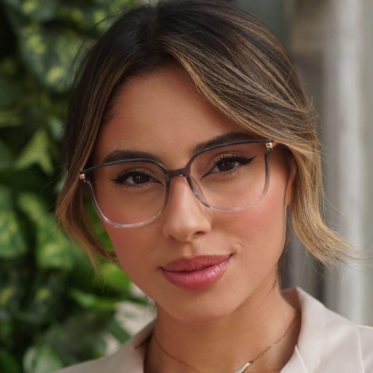 Óculos multifocal feminino com lentes transparentes, armação leve nas cores preta e marrom translúcida. Modelo com proteção contra luz azul e design sofisticado para uso diário.