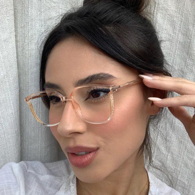 Óculos multifocal feminino com lentes transparentes, armação leve nas cores preta e marrom translúcida. Modelo com proteção contra luz azul e design sofisticado para uso diário.