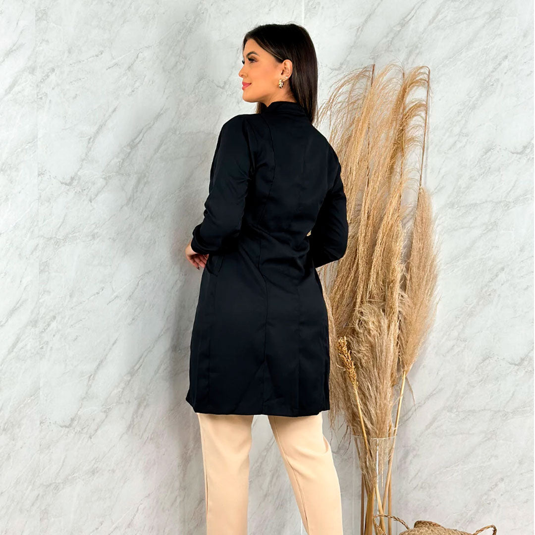 Jaleco feminino de manga longa com punhos, gola padre e zíper frontal dourado. Modelo acinturado em tecido gabardine com bolsos laterais. Disponível nas cores branca e preta.