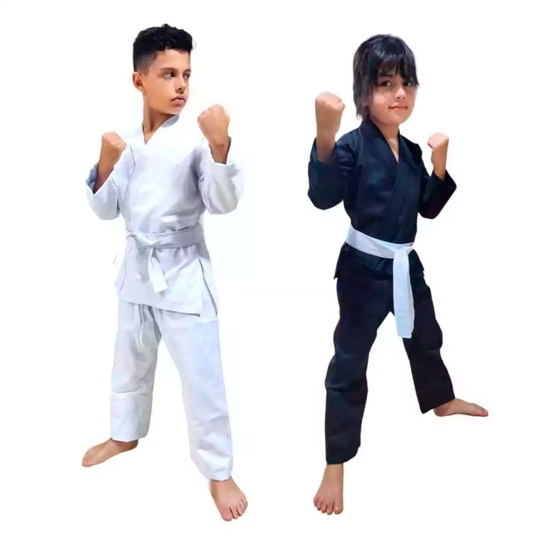Crianças vestidas com kimono de karatê infantil nas cores branco e preto, com faixa branca. Confeccionado em brim reforçado, ideal para treinos, com ajuste confortável e tecido resistente.