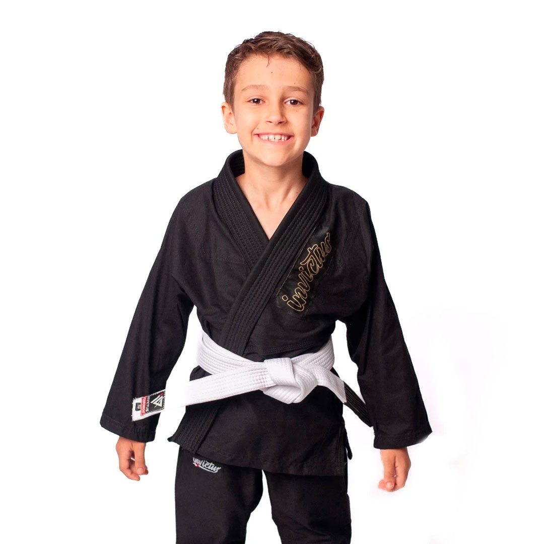 Criança usando kimono infantil azul para judô ou jiu-jitsu, feito em sarja 100% algodão, com reforços visíveis e gola estruturada, ideal para iniciantes no tatame.