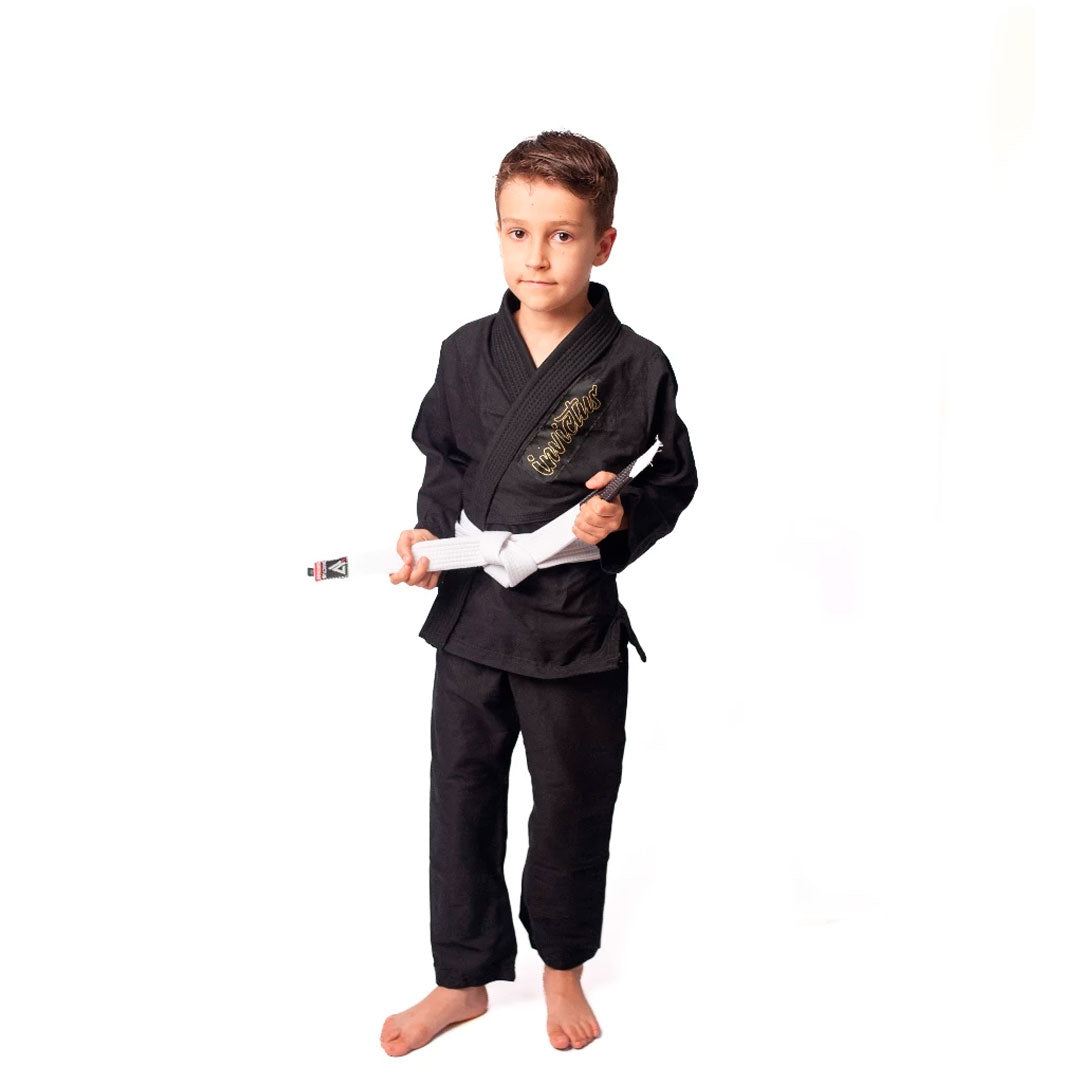 Criança usando kimono infantil azul para judô ou jiu-jitsu, feito em sarja 100% algodão, com reforços visíveis e gola estruturada, ideal para iniciantes no tatame.