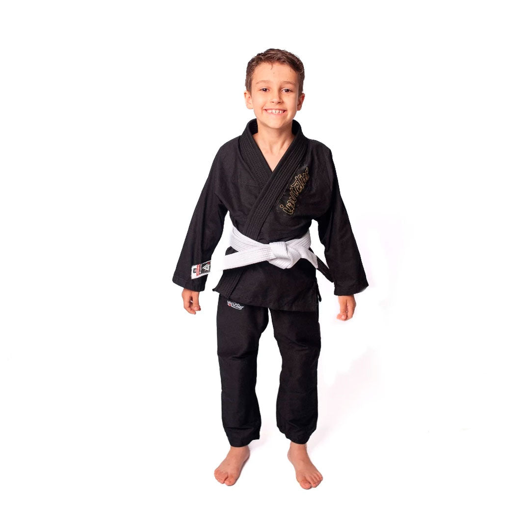 Criança usando kimono infantil azul para judô ou jiu-jitsu, feito em sarja 100% algodão, com reforços visíveis e gola estruturada, ideal para iniciantes no tatame.