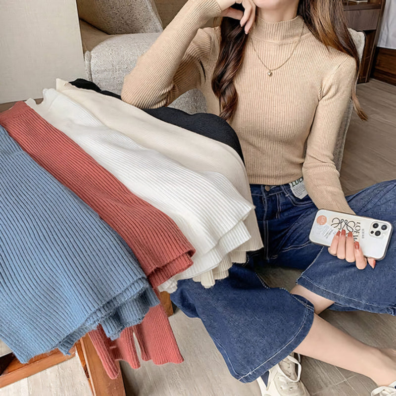 Blusa cacharrel feminina em tricot canelado com gola alta, manga longa e modelagem ajustada. Estilo básico e elegante para usar no frio com saias, calças ou sobreposições.