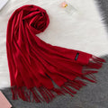 Cachecol feminino longo com toque suave de caxemira em cores sofisticadas como vermelho, cinza e creme. Ideal para dias frios e meia-estação, com franjas elegantes e caimento leve.