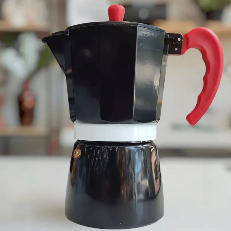 Cafeteira Italiana tradicional em alumínio com detalhes em vermelho. Prepara até 6 xícaras de 50ml com eficiência e segurança. Design moderno, leve e ergonômico, ideal para café espresso intenso em casa.