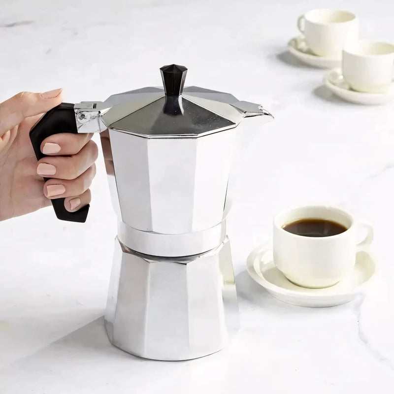 Cafeteira italiana clássica em alumínio polido, com cabo ergonômico preto. Prepara café encorpado no fogão, disponível em tamanhos de 3, 6 ou 9 xícaras. Ideal para um café artesanal com aroma intenso.