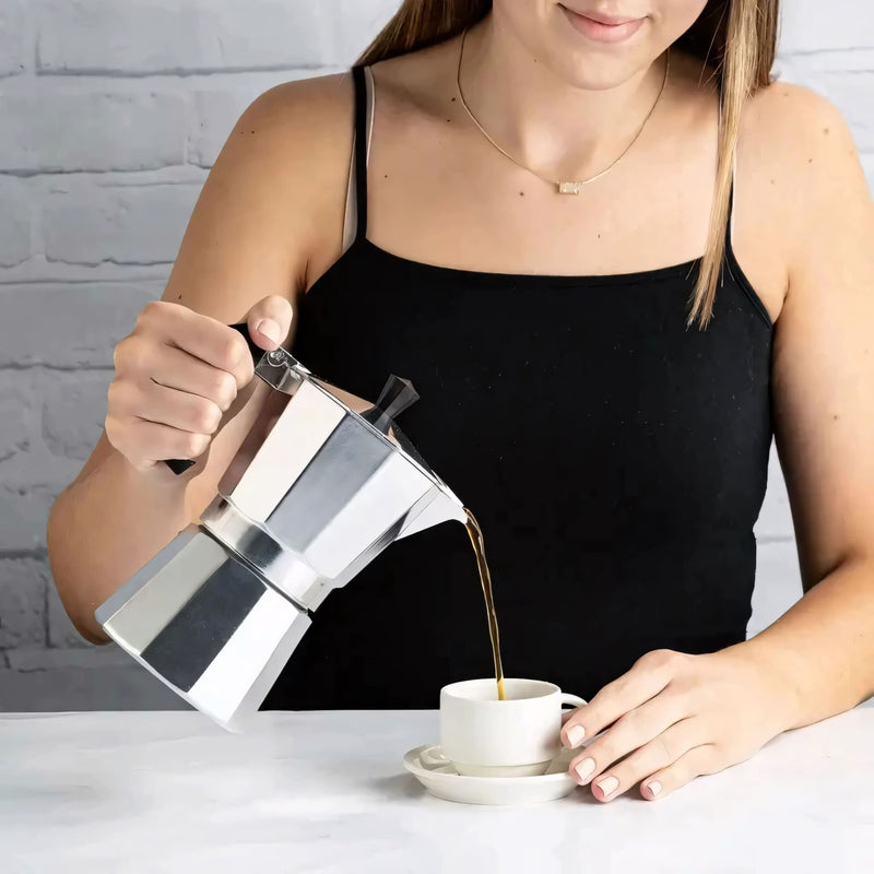 Cafeteira italiana clássica em alumínio polido, com cabo ergonômico preto. Prepara café encorpado no fogão, disponível em tamanhos de 3, 6 ou 9 xícaras. Ideal para um café artesanal com aroma intenso.
