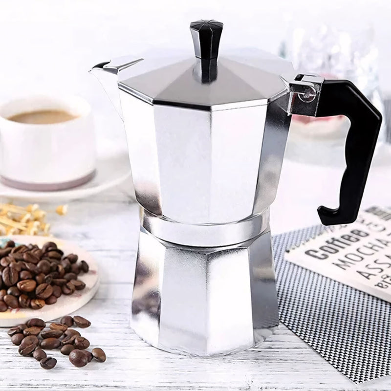 Cafeteira italiana clássica em alumínio polido, com cabo ergonômico preto. Prepara café encorpado no fogão, disponível em tamanhos de 3, 6 ou 9 xícaras. Ideal para um café artesanal com aroma intenso.