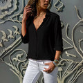 Mulher usando camisa feminina de tecido leve e caimento solto, com manga longa dobrada. Peça elegante e versátil, ideal para looks casuais e formais com conforto e sofisticação.