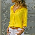 Mulher usando camisa feminina de tecido leve e caimento solto, com manga longa dobrada. Peça elegante e versátil, ideal para looks casuais e formais com conforto e sofisticação.