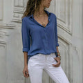 Mulher usando camisa feminina de tecido leve e caimento solto, com manga longa dobrada. Peça elegante e versátil, ideal para looks casuais e formais com conforto e sofisticação.