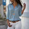 Mulher usando camisa feminina de tecido leve e caimento solto, com manga longa dobrada. Peça elegante e versátil, ideal para looks casuais e formais com conforto e sofisticação.