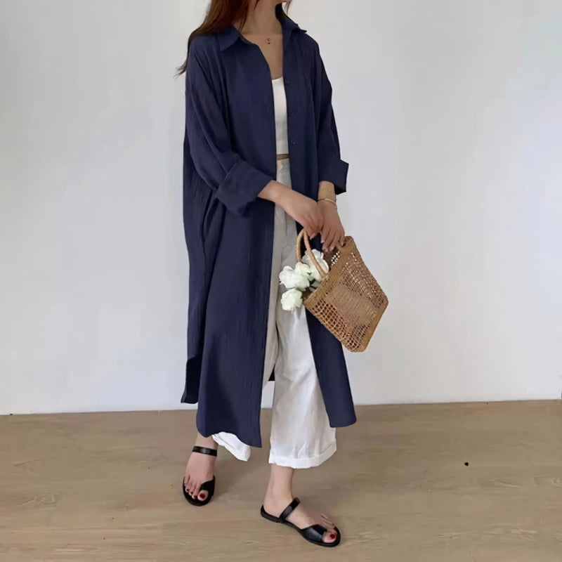Modelo veste o Chemise Natural Serena em tom claro, com caimento leve, manga longa dobrada e visual minimalista. Ideal para looks casuais, de verão ou urbanos, com toque suave do linho e conforto respirável.