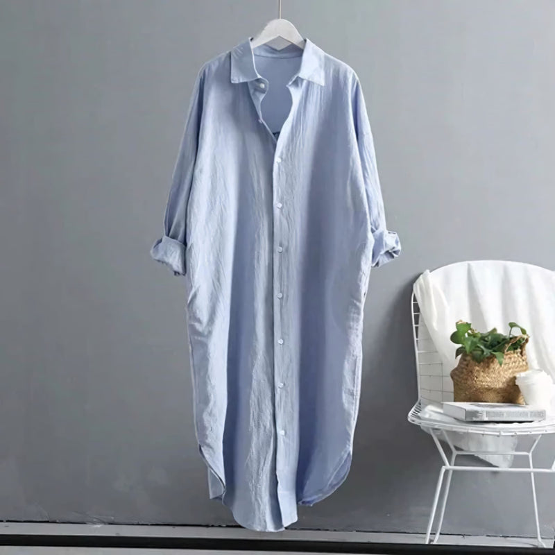 Modelo veste o Chemise Natural Serena em tom claro, com caimento leve, manga longa dobrada e visual minimalista. Ideal para looks casuais, de verão ou urbanos, com toque suave do linho e conforto respirável.