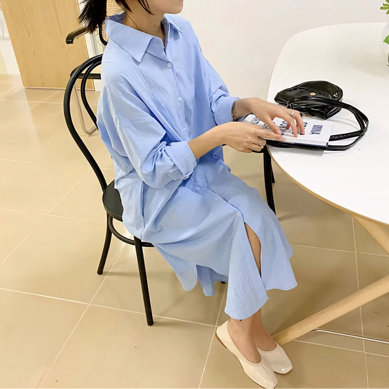 Modelo veste o Chemise Natural Serena em tom claro, com caimento leve, manga longa dobrada e visual minimalista. Ideal para looks casuais, de verão ou urbanos, com toque suave do linho e conforto respirável.