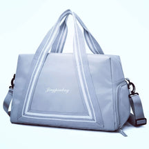 Bolsa de viagem compacta e leve, ideal como mala de mão. Com alças duplas, tiracolo ajustável, bolso lateral e design moderno. Unissex e enviada em cores variadas.