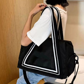 Bolsa de viagem compacta e leve, ideal como mala de mão. Com alças duplas, tiracolo ajustável, bolso lateral e design moderno. Unissex e enviada em cores variadas.