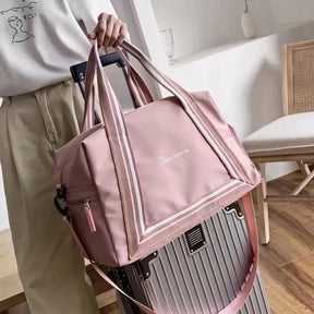 Bolsa de viagem compacta e leve, ideal como mala de mão. Com alças duplas, tiracolo ajustável, bolso lateral e design moderno. Unissex e enviada em cores variadas.