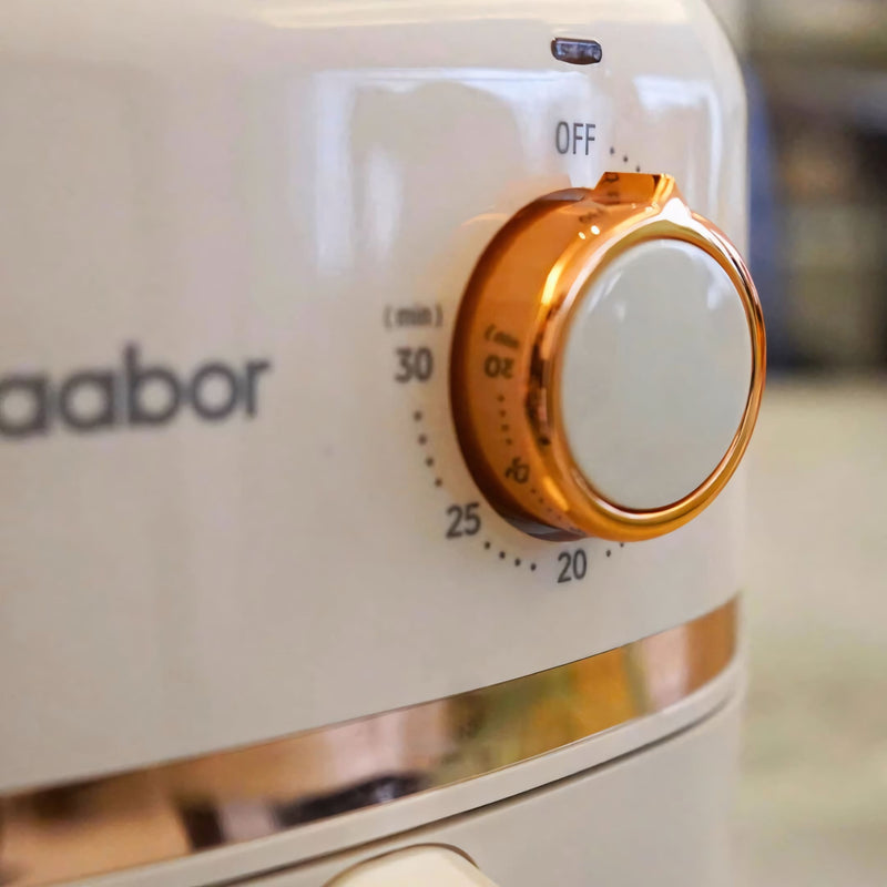 Fritadeira elétrica Gaabor com 1,4 litros, acabamento sofisticado em creme com detalhes dourados, timer analógico e tecnologia Cyclone Air para receitas crocantes sem óleo.