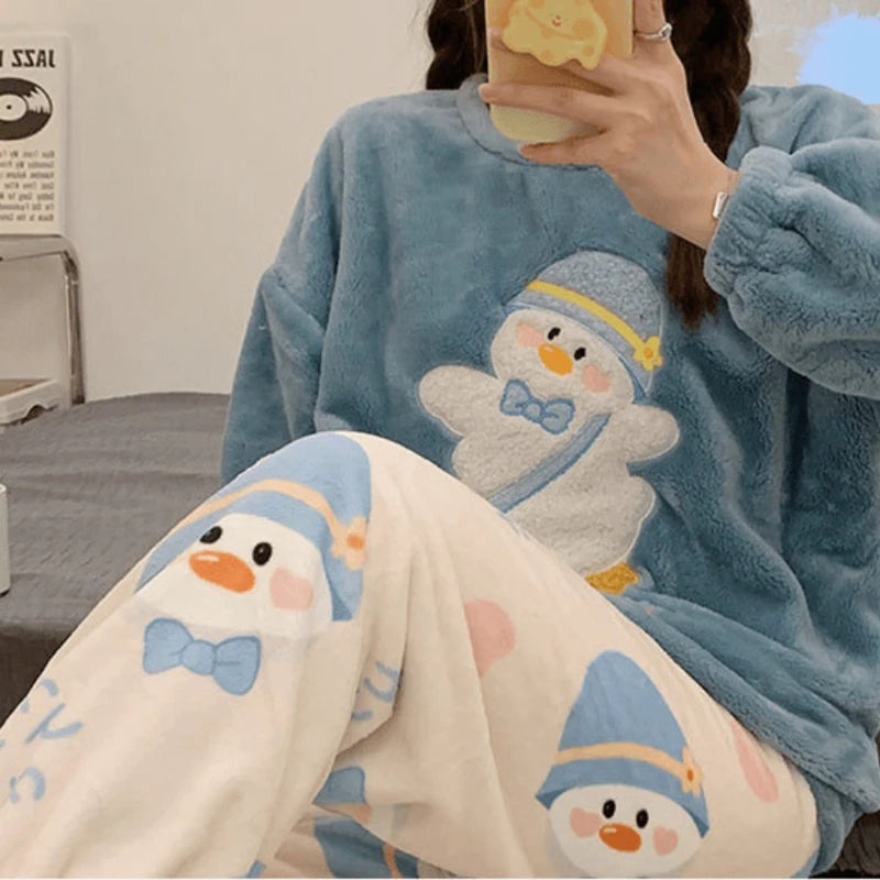Mulher vestindo pijama longo de inverno com estampa de pinguim azul e branco, tecido flanelado aconchegante, ideal para noites frias e momentos de relaxamento.