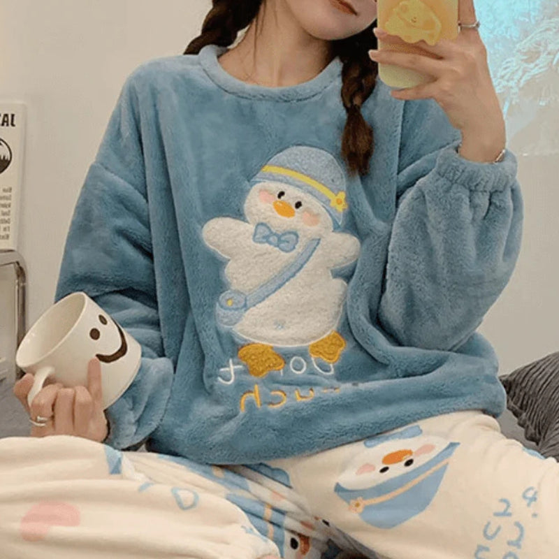 Mulher vestindo pijama longo de inverno com estampa de pinguim azul e branco, tecido flanelado aconchegante, ideal para noites frias e momentos de relaxamento.