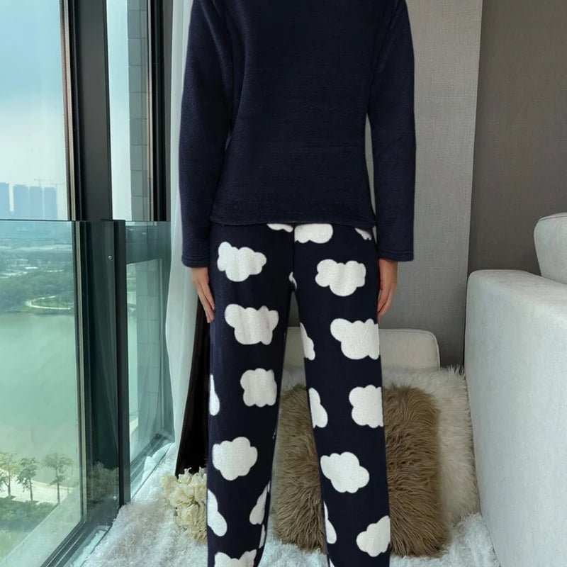 Mulher vestindo o Pijama Longo Cílios em tecido peluciado com estampa de nuvem e bordado de cílios nos olhos, ideal para noites frias e cheias de conforto.

