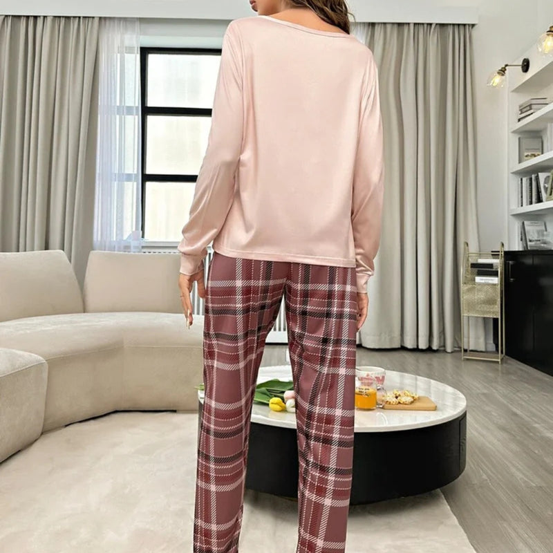 Mulher usando o Pijama Longo Xadrez Bear com blusa rosa estampada de ursinho e calça xadrez em tons terrosos, ideal para noites confortáveis com estilo casual.