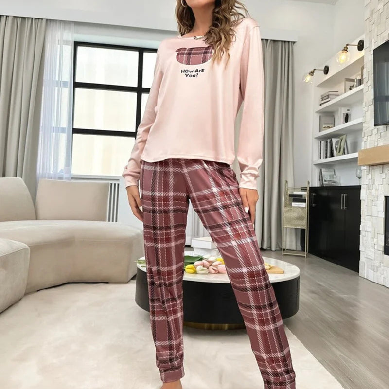 Mulher usando o Pijama Longo Xadrez Bear com blusa rosa estampada de ursinho e calça xadrez em tons terrosos, ideal para noites confortáveis com estilo casual.