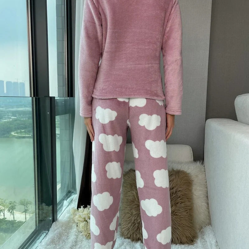 Mulher vestindo o Pijama Longo Cílios em tecido peluciado com estampa de nuvem e bordado de cílios nos olhos, ideal para noites frias e cheias de conforto.

