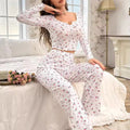 Mulher usando Pijama Longo Rose com estampa floral, blusa de manga comprida com botões decorativos e calça confortável. Ideal para dormir ou relaxar com estilo e conforto.