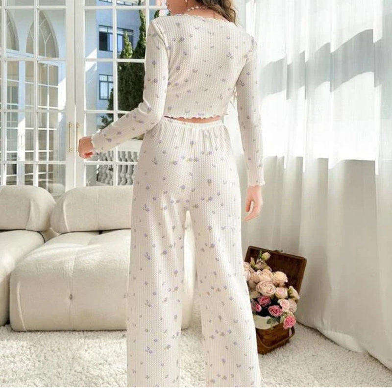 Mulher usando Pijama Longo Violet com blusa de manga longa e botões, calça confortável e estampa floral lilás. Pijama feminino delicado e elegante para noites aconchegantes.