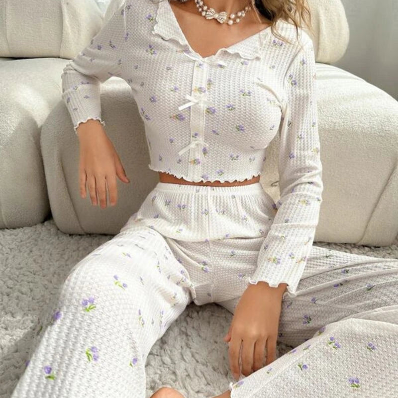 Mulher usando Pijama Longo Violet com blusa de manga longa e botões, calça confortável e estampa floral lilás. Pijama feminino delicado e elegante para noites aconchegantes.