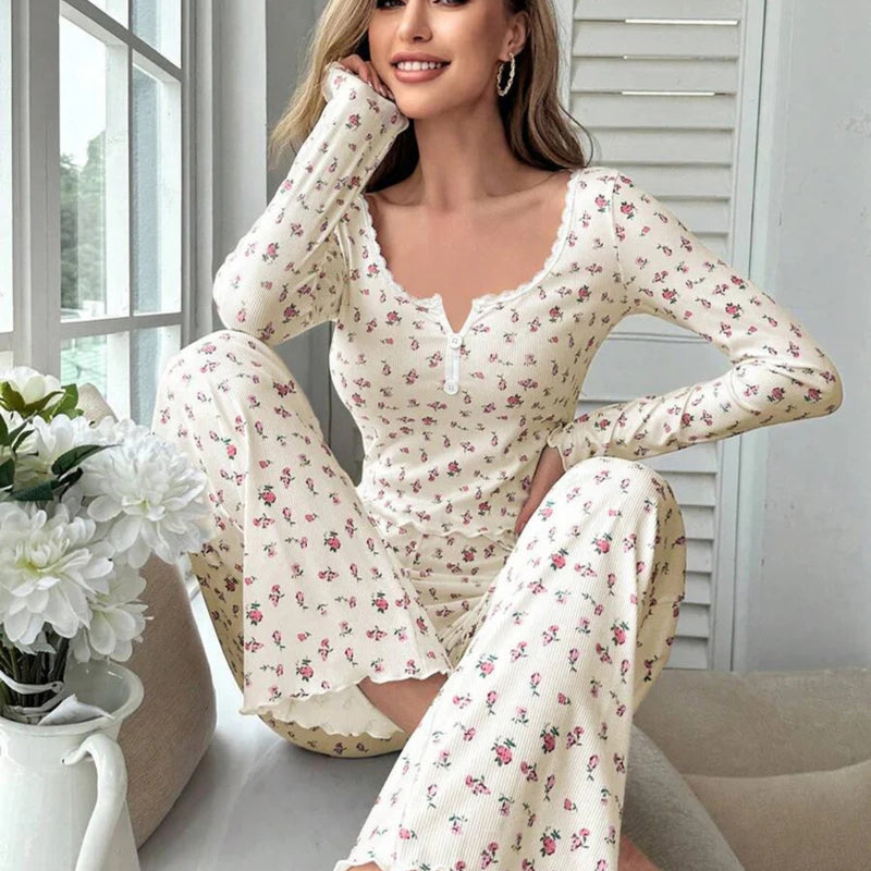 Mulher usando Pijama Longo Rose com estampa floral, blusa de manga comprida com botões decorativos e calça confortável. Ideal para dormir ou relaxar com estilo e conforto.