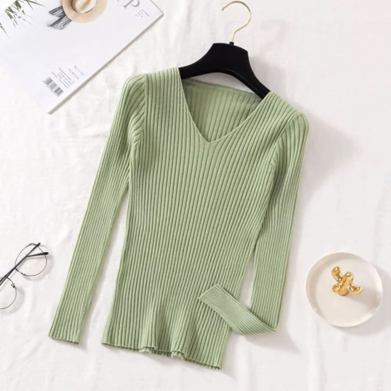 Suéter feminino em tricot canelado com gola V, manga longa e modelagem ajustada. Ideal para dias frios, combina com jeans, alfaiataria e looks casuais elegantes.