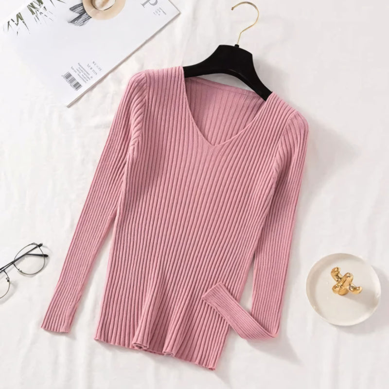 Suéter feminino em tricot canelado com gola V, manga longa e modelagem ajustada. Ideal para dias frios, combina com jeans, alfaiataria e looks casuais elegantes.