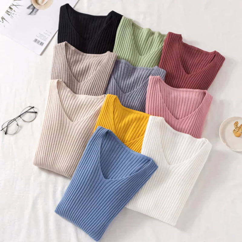 Suéter feminino em tricot canelado com gola V, manga longa e modelagem ajustada. Ideal para dias frios, combina com jeans, alfaiataria e looks casuais elegantes.