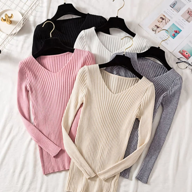 Suéter feminino em tricot canelado com gola V, manga longa e modelagem ajustada. Ideal para dias frios, combina com jeans, alfaiataria e looks casuais elegantes.