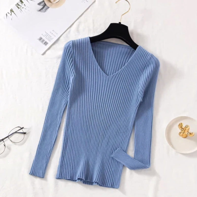 Suéter feminino em tricot canelado com gola V, manga longa e modelagem ajustada. Ideal para dias frios, combina com jeans, alfaiataria e looks casuais elegantes.