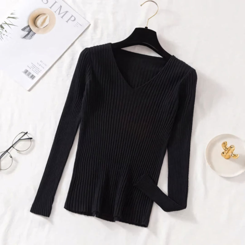 Suéter feminino em tricot canelado com gola V, manga longa e modelagem ajustada. Ideal para dias frios, combina com jeans, alfaiataria e looks casuais elegantes.