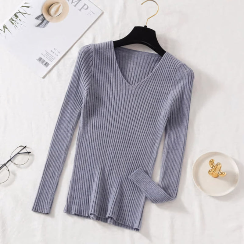 Suéter feminino em tricot canelado com gola V, manga longa e modelagem ajustada. Ideal para dias frios, combina com jeans, alfaiataria e looks casuais elegantes.