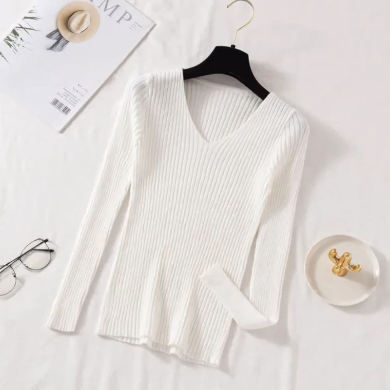 Suéter feminino em tricot canelado com gola V, manga longa e modelagem ajustada. Ideal para dias frios, combina com jeans, alfaiataria e looks casuais elegantes.