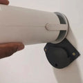 Suporte de parede preto para projetor Magcubic fixado em parede branca, com encaixe preciso e acabamento discreto. Ideal para manter o projetor firme e centralizado.