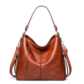 Bolsa de couro feminina com alça dupla, zíper seguro e design elegante. Modelo versátil, disponível em preto e caramelo, ideal para o dia a dia com estilo e sofisticação.