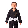 Criança usando kimono infantil azul para judô ou jiu-jitsu, feito em sarja 100% algodão, com reforços visíveis e gola estruturada, ideal para iniciantes no tatame.