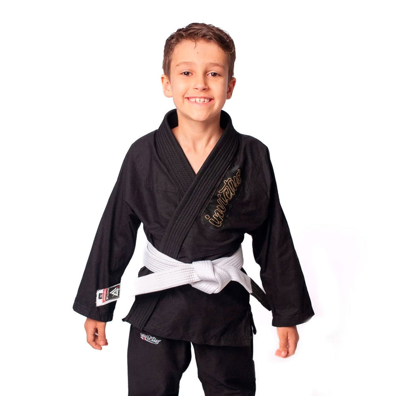 Criança usando kimono infantil azul para judô ou jiu-jitsu, feito em sarja 100% algodão, com reforços visíveis e gola estruturada, ideal para iniciantes no tatame.